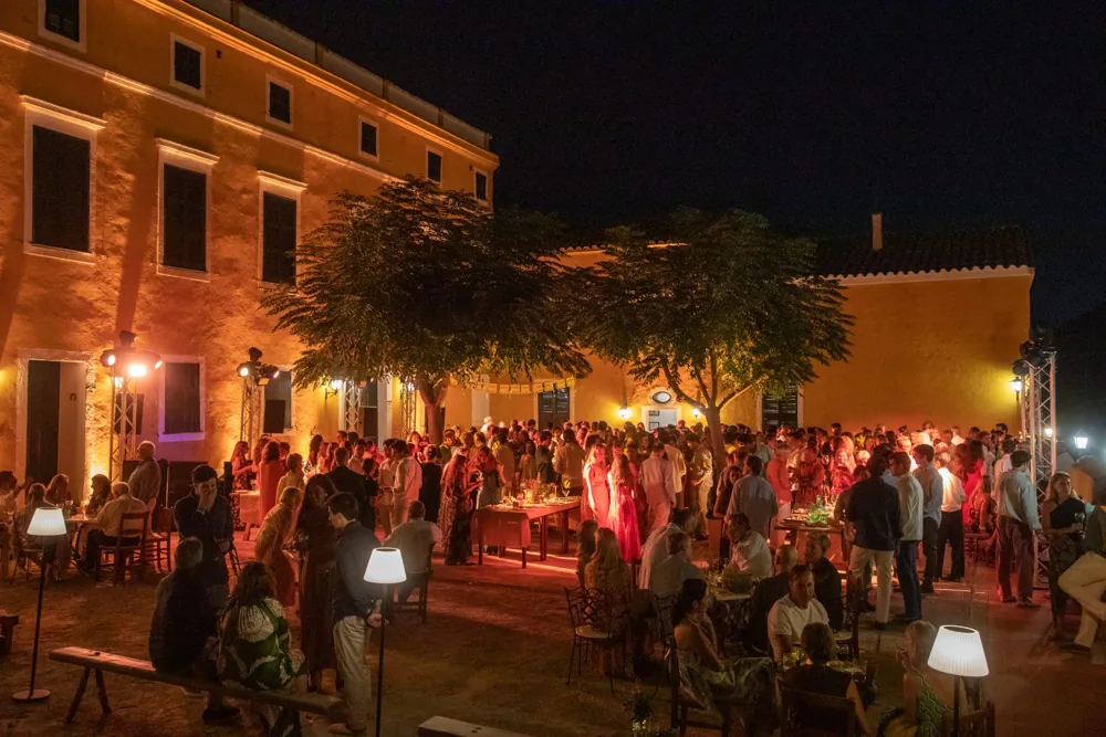 Invitados reunidos junto a la casa iluminada de Binissuès